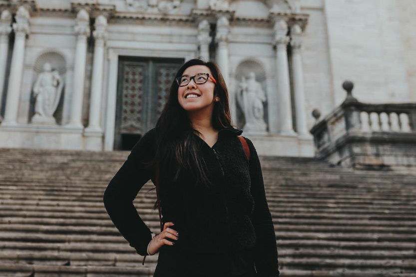 Student standing on the steps gazing at the sky