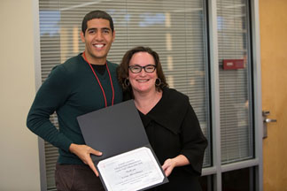 Student and a faculty member holding a certificate