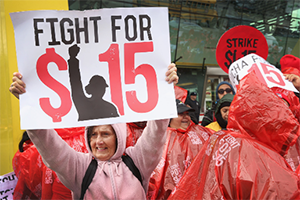 A protester holding a sign that says, "Fight for $15"