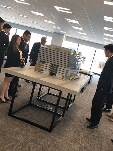 Group of students observing a model of a building