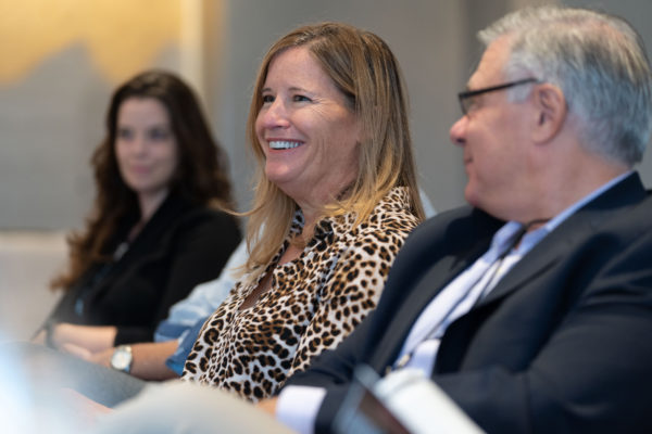 A woman smiling at a roundtable meeting