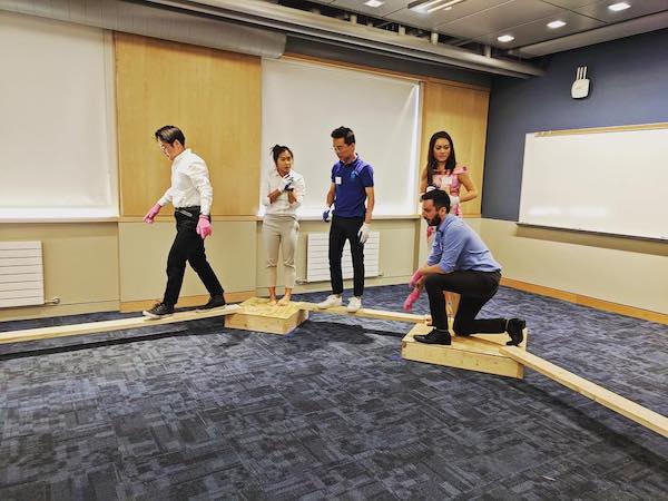 Students move blocks of wood in a team building activity