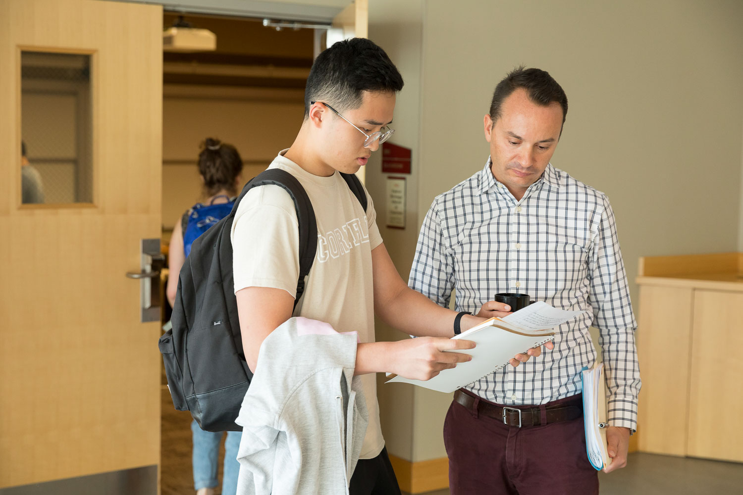 Two men talking and looking at papers together