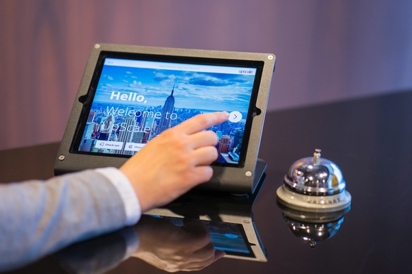 A person checks into a hotel using a tablet.