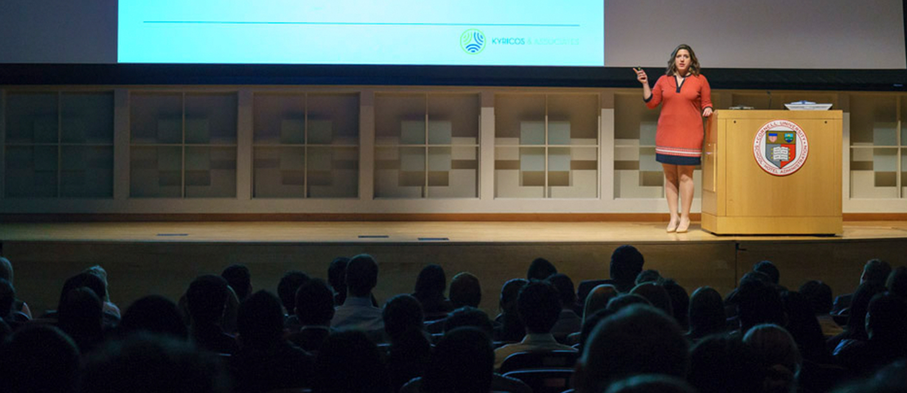 Woman presenting on stage in an auditorium