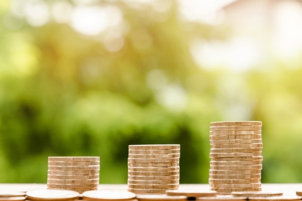 Three stacks of coins. From left to right, each stack is progressively taller to illustrate profit.