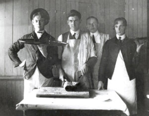 students in kitchen dressed to provide dinner service.