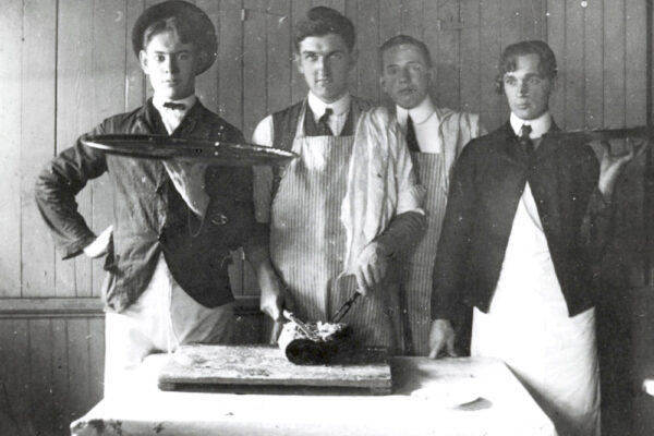 students in kitchen dressed to provide dinner service.