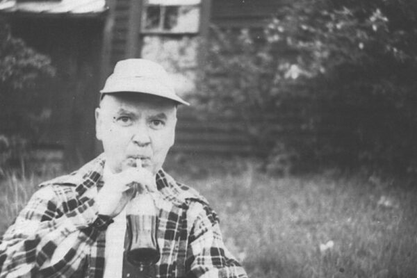 hb meek wearing flannel while drinking soda out of a glass bottle