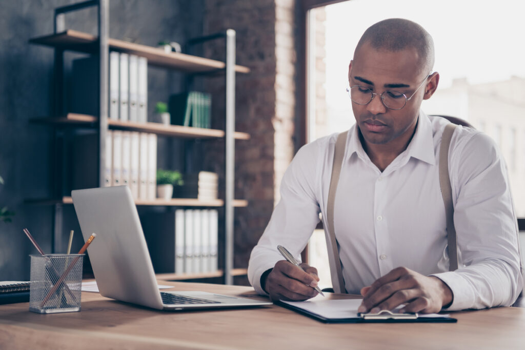 Portrait of his he nice stylish busy focused guy chairman real estate, financier manager writing finance sales plan strategy growth at industrial loft interior work place station