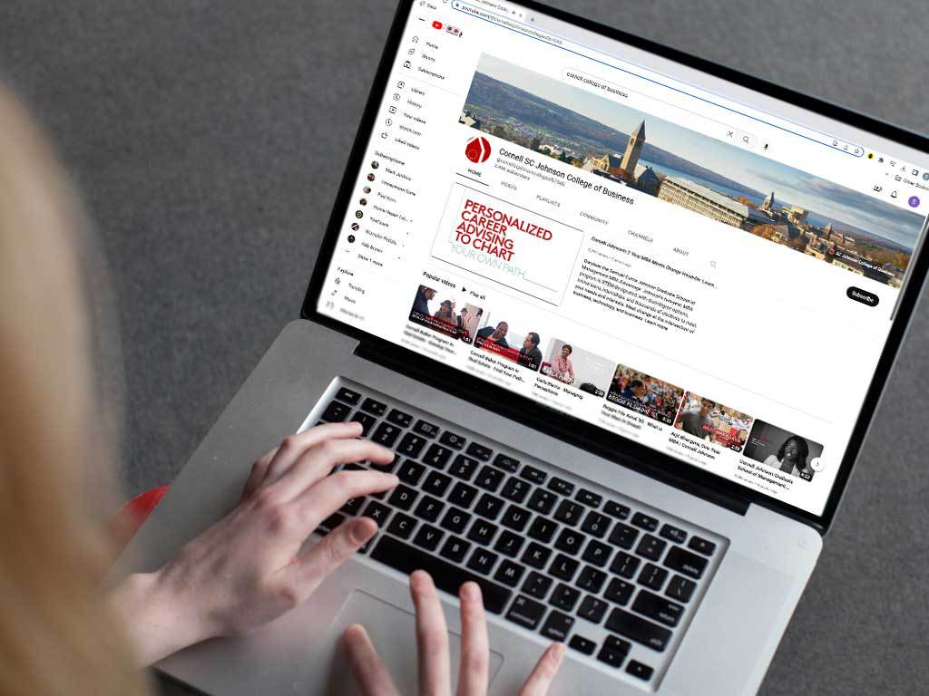 A person with long hair interacts with the Cornell SC Johnson College of BUsiness Youtube page.