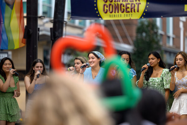 People celebrating outside with balloon animals visible.
