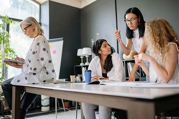 Office setting with four women collaborating.