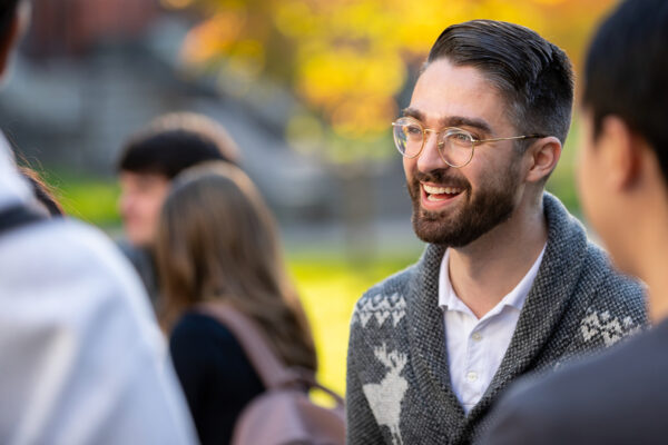 Student smiling while talking to another student.