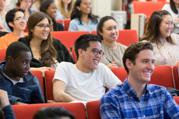 Students listening and smiling to a lecture.