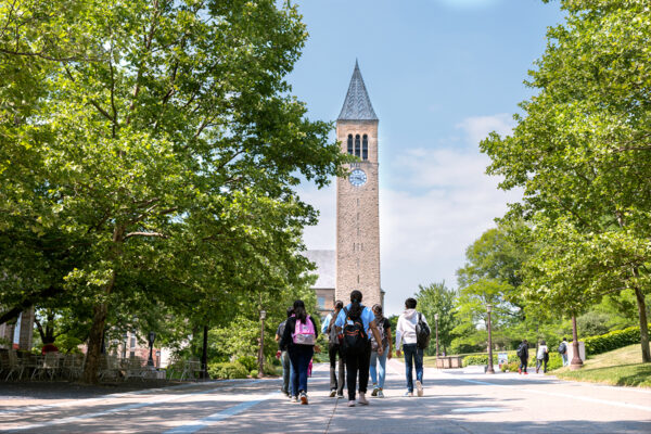 Students walking toward McGraw Tower on a summer day.