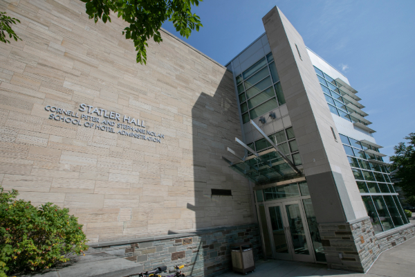 The exterior of Statler Hall, shot close to the entrance looking up toward blue sky.