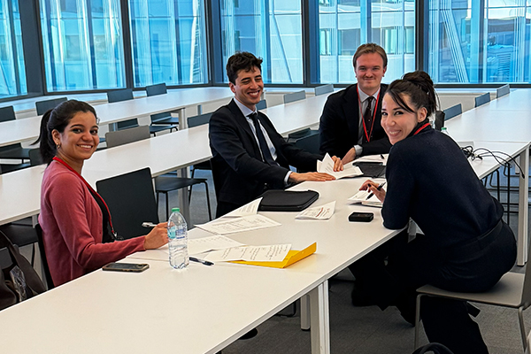 Team SKEMA and coach Ambra Mazzelli huddle in a classroom to prepare for their team’s case competition presentation.